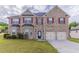 Charming brick two-story home with a well-manicured lawn and attached two-car garage at 204 Saintvry Path, Atlanta, GA 30349
