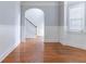Hallway with hardwood flooring, wainscoting, and an arched entry to the stairs at 204 Saintvry Path, Atlanta, GA 30349