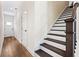 Bright entryway with hardwood floors, staircase with dark wood treads, and a white front door at 213 Starr Cir, Stockbridge, GA 30281