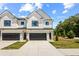 Charming new construction townhome with white siding, dark garage door, and landscaped front yard at 213 Starr Cir, Stockbridge, GA 30281