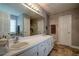 Bathroom with double sinks, white cabinets, large mirror, and separate shower and bathtub at 3265 Bethesda Park Ct, Lawrenceville, GA 30044