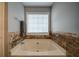 Close up of bathtub with decorative tile surround and a window for natural light at 3265 Bethesda Park Ct, Lawrenceville, GA 30044
