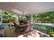 Covered patio with a table and seating, offering a relaxing outdoor space surrounded by lush greenery at 3265 Bethesda Park Ct, Lawrenceville, GA 30044