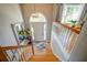 Grand entryway featuring a wooden staircase, an elegant chandelier, and a mirrored side table with fresh flowers at 3265 Bethesda Park Ct, Lawrenceville, GA 30044