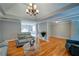 Spacious living room offering hardwood floors, a tray ceiling, neutral paint colors, and a modern glass coffee table at 3265 Bethesda Park Ct, Lawrenceville, GA 30044
