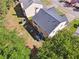 Aerial view of the property highlighting the backyard patio, play area, and lush trees surrounding the home at 5035 Pattingham Dr, Roswell, GA 30075