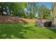 Spacious backyard with green grass, a patio, a grill, and mature trees, ideal for outdoor entertaining and relaxation at 5035 Pattingham Dr, Roswell, GA 30075