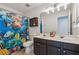 Well-lit bathroom showcasing a double sink vanity and vibrant sea life-themed shower curtain, adding a pop of color at 5035 Pattingham Dr, Roswell, GA 30075