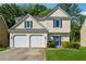 Charming two-story home featuring a two-car garage, well-manicured lawn and blue accent shutters at 5035 Pattingham Dr, Roswell, GA 30075