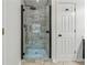 Modern bathroom shower featuring sleek glass doors and stylish stone-look tiling for a luxurious bathing experience at 5035 Pattingham Dr, Roswell, GA 30075