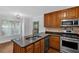Well-lit kitchen features stainless steel appliances, wood cabinets, and a granite countertop island at 1438 N Crossing Ne Dr, Atlanta, GA 30329