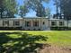 Classic white brick home with a well-manicured lawn, complemented by wooden accents and greenery at 2678 Stardust Trl, Decatur, GA 30034