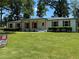 Well-maintained lawn leads up to a classic white brick home with prominent wooden accents and trimmed green hedges at 2678 Stardust Trl, Decatur, GA 30034