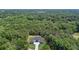 Aerial view of an expansive property showcasing a modern home surrounded by lush, dense forest at 2843 N North Bogan Rd, Buford, GA 30519