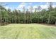 Large backyard featuring level lot with newly installed sod and surrounding mature trees at 2843 N North Bogan Rd, Buford, GA 30519