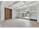 Living room featuring hardwood floors, tray ceilings, large windows, and a custom wine rack at 2843 N North Bogan Rd, Buford, GA 30519