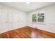Bright, empty bedroom with hardwood floors, neutral paint, and closet at 3314 Glenco Dr, Decatur, GA 30032