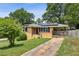 Brick home featuring solar panels, a carport, and a neatly kept front lawn on a sunny day at 3314 Glenco Dr, Decatur, GA 30032