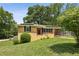Charming brick home with solar panels, a well-manicured lawn and a bright red front door at 3314 Glenco Dr, Decatur, GA 30032