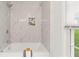 Modern bathroom featuring white marble tiles, a soaking tub, and recessed shelving at 4723 N Springs Nw Rd, Kennesaw, GA 30144