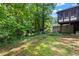 Lush backyard featuring mature trees and the side of a two-story home with multiple windows at 3441 Sherrod Sw Dr, Marietta, GA 30060
