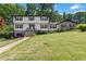 Traditional two-story home with a well-manicured lawn, enhanced by mature trees and a brick facade at 3441 Sherrod Sw Dr, Marietta, GA 30060