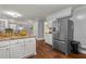 Kitchen with stainless refrigerator, white cabinets, granite countertops, and hardwood floors at 3441 Sherrod Sw Dr, Marietta, GA 30060