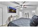 Bright bedroom showcasing a bed, ceiling fan, wall-mounted TV, and modern dresser at 3819 Shane Ct, Ellenwood, GA 30294
