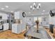Modern kitchen and dining area featuring white cabinets, stainless steel appliances, and wooden floors at 3819 Shane Ct, Ellenwood, GA 30294
