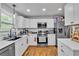 Bright kitchen with stainless appliances, white cabinets, granite counters, and hardwood floors at 3819 Shane Ct, Ellenwood, GA 30294