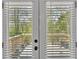 View of a peaceful outdoor patio through double doors with privacy blinds at 3819 Shane Ct, Ellenwood, GA 30294