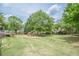 Expansive backyard with a lush lawn, mature trees, and an outdoor seating area with red Adirondack chairs at 435 Chantenay Pl, Alpharetta, GA 30022