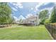 Spacious backyard featuring a large deck, green lawn, and a fire pit area with red chairs at 435 Chantenay Pl, Alpharetta, GA 30022