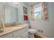 Well-lit bathroom features a granite-topped vanity, matching towel rack, and a window dressed with patterned curtains at 435 Chantenay Pl, Alpharetta, GA 30022