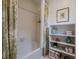 Cozy bathroom with a tub/shower combo and a shelving unit for storage and decor at 435 Chantenay Pl, Alpharetta, GA 30022