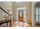 The foyer features a wooden door, hardwood floors, stairs with a black handrail, and access to other rooms at 435 Chantenay Pl, Alpharetta, GA 30022
