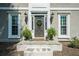 Close-up of the front door with decorative wreath, sidelights, potted plants, and stone steps at 435 Chantenay Pl, Alpharetta, GA 30022