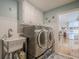Convenient laundry room with a utility sink, washer, dryer, and ample storage cabinets at 435 Chantenay Pl, Alpharetta, GA 30022