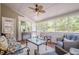 A well-lit sunroom features comfortable seating, a ceiling fan, and large windows with views of the backyard at 435 Chantenay Pl, Alpharetta, GA 30022