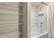 Bathroom featuring a tub with tile surround and organized closet space at 10786 Wheeler Trce, Hampton, GA 30228