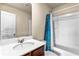 Bathroom featuring a vanity with dark wood finish, white countertop, and a shower with a blue curtain at 10786 Wheeler Trce, Hampton, GA 30228