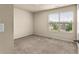 This vacant bedroom is carpeted and has a large window offering a nice view of the neighborhood at 10786 Wheeler Trce, Hampton, GA 30228