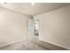 A vacant bedroom is carpeted and features white walls and trim, with an open door leading to another room at 10786 Wheeler Trce, Hampton, GA 30228