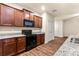 Kitchen with dark wood cabinets, granite countertops, and black appliances at 10786 Wheeler Trce, Hampton, GA 30228