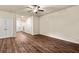 Open-concept living room featuring hardwood floors, ceiling fan, and access to other rooms at 10786 Wheeler Trce, Hampton, GA 30228