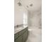 Bright bathroom featuring marble shower, white herringbone floors, and olive vanity at 11536 Serenbe Ln, Chattahoochee Hills, GA 30268