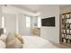 Bright bedroom featuring light wood floors, neutral décor, and a bookcase at 11536 Serenbe Ln, Chattahoochee Hills, GA 30268