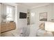 Bright bedroom with light wood floors, neutral décor, and a large TV at 11536 Serenbe Ln, Chattahoochee Hills, GA 30268