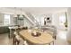 Sunlit living area with an adjacent kitchen featuring bar seating and stainless steel appliances at 11536 Serenbe Ln, Chattahoochee Hills, GA 30268