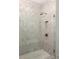 Modern shower with light herringbone tiling, a built-in niche, and gold hardware at 11536 Serenbe Ln, Chattahoochee Hills, GA 30268